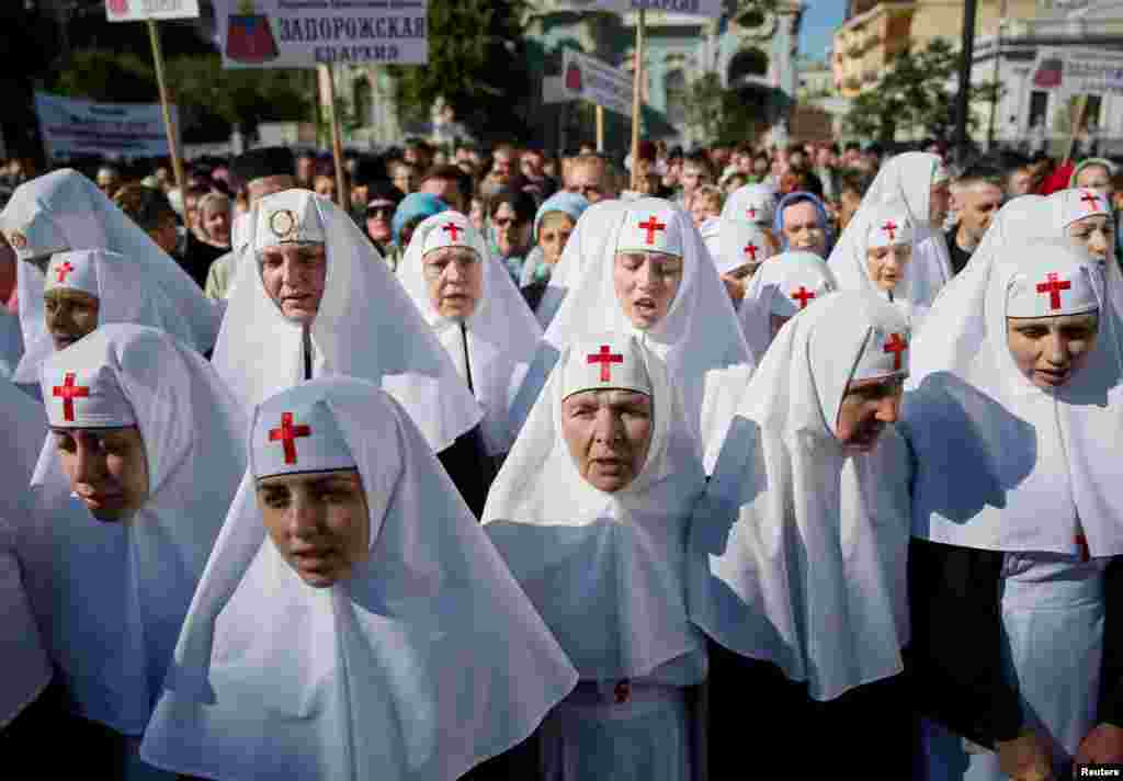 Monah aýallar we Moskwa patriarhatynyň ukrain prawoslaw ybadathanasyna eýerijiler 18-nji maýda ukrain parlamentiniň öňünde ýygnanyşyga gatnaşýarlar. Olar Kiýewe öz ybadathanalary babatda has kän ygtyýar berjek kanun taslamasyna protest bildirýärler. (Reuters/Gleb Garanich)