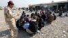 An Iraqi soldier speaks with displaced men from Mosul on November 27.