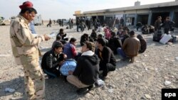 An Iraqi soldier speaks with displaced men from Mosul on November 27.