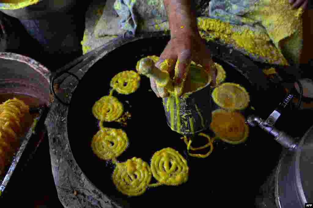 An Afghan makes sweets at a traditional &quot;jelabi&quot; factory in Herat during the month of Ramadan. (AFP/Aref Karimi)
