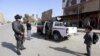 A boy looks on while waiting for soldiers to finish searching a vehicle and his father at a checkpoint in central Baghdad ahead of the Arab League summit later this week. 