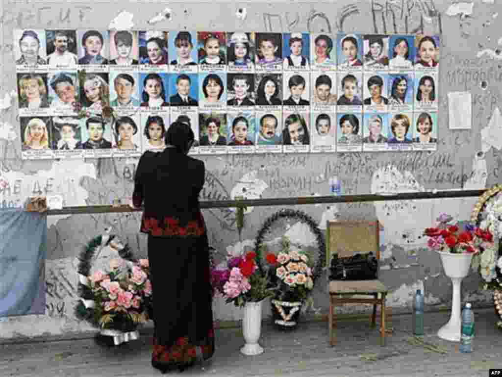 Russia -- A woman stands near children's pictures in the destroyed school sport hall in Beslan, 30May2007