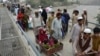 An Afghan man pushes a cart with a woman and children as they cross the border between Afghanistan and Pakistan in the Torkham (file photo).