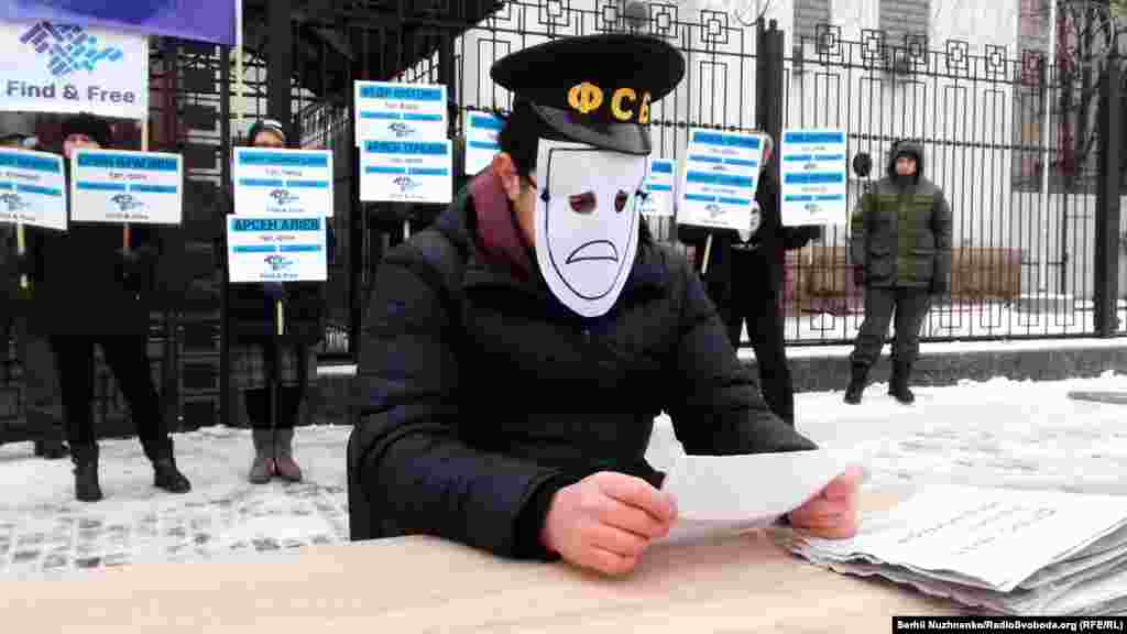 Во время акции, активист, играя роль следователя, сидел за столом, на котором были папки с делами пропавших без вести в аннексированном Крыму