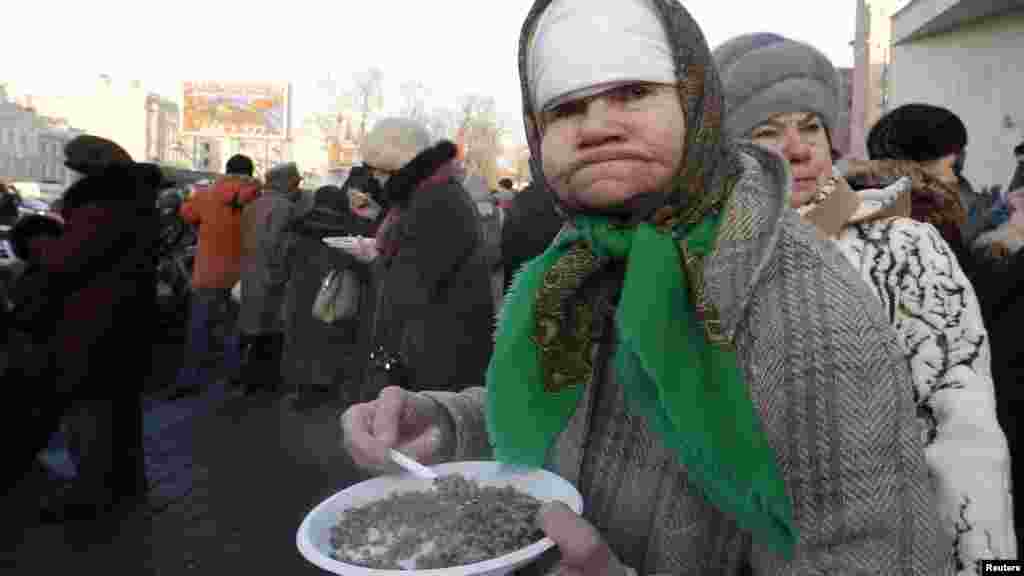 A woman eats a plate of boiled buckwheat during a street event in St. Petersburg. Russians on January 27 marked the end of the 872-day siege of Leningrad in 1943, which claimed the lives of more than 500,000 people. (REUTERS/Alexander Demianchuk)