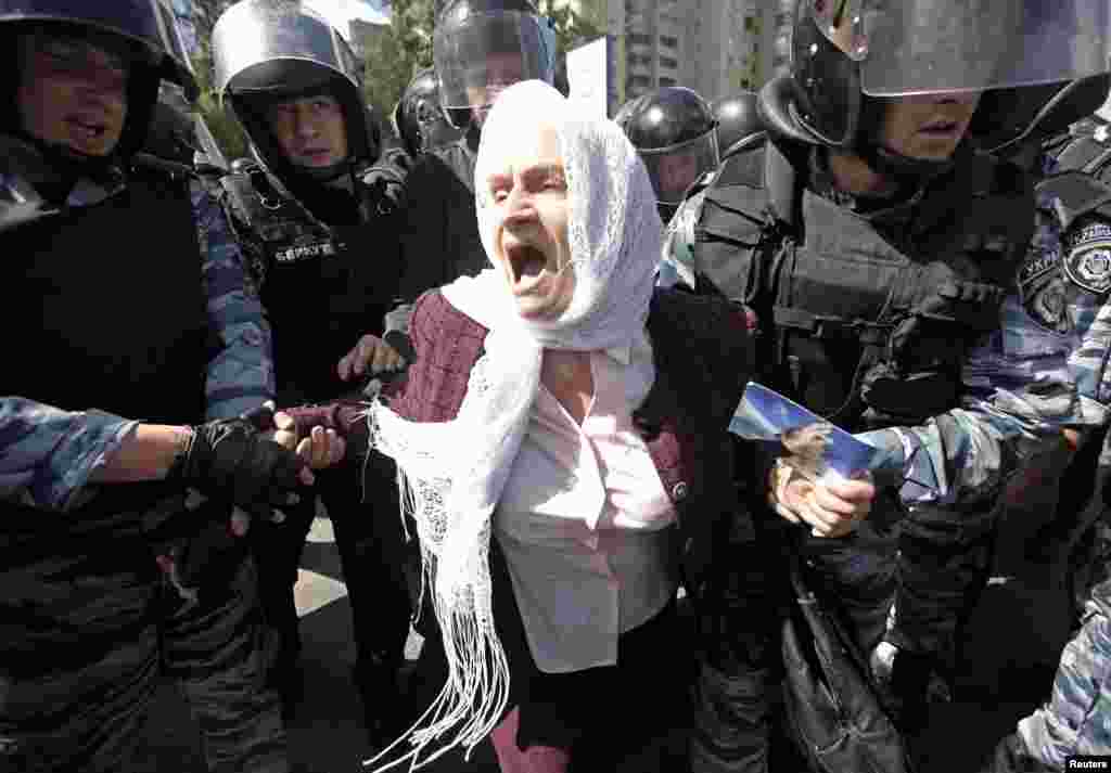 Ukrainian riot police detain an elderly Orthodox Christian activist as she protests against a gay-pride parade in Kyiv on May 25. (Reuters)