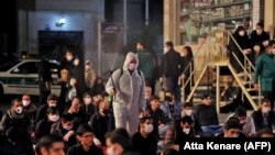 Iranians, some wearing face masks against the coronavirus, attend prayers during the Muslim fasting month of Ramadan, outside a mosque in the Tehran, May 13, 2020