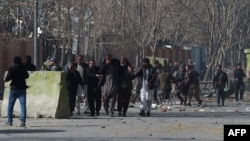 Policët dhe vullnetarët duke u ndihmuar personave të plagosur nga sulmi i sotëm në Kabul