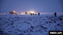 A handout photo from Russian authorities showing emergency workers at the scene of a AN-148 plane crash in Stepanovskoye, about 40 kilometers from Moscow's Domodedovo Airport.