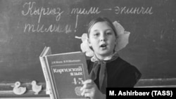 Вучаніца 4-й клясы расейскамоўнай школы ў Джалал-Абадзе Ліна Савенка на ўроку кіргіскай мовы, 1988 год. Надпіс на дошцы: «Кіргіская мова — твая другая мова!»