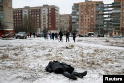 The body of a woman killed by shelling lies in a residential area in the eastern town of Kramatorsk on February 10.