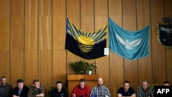 All eight members of the seized OSCE team sit at a press conference in Slovyansk alongside separatist leader Vyacheslav Ponomaryov (fourth from left), who has called them "NATO spies" and "prisoners of war."