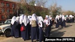 Мектепке орамалын шешіп келуден бас тартқан қыздар мектепке кіре алмай тұр. Фердауси ауылы, Түркістан облысы, 5 қыркүйек 2018 жыл.