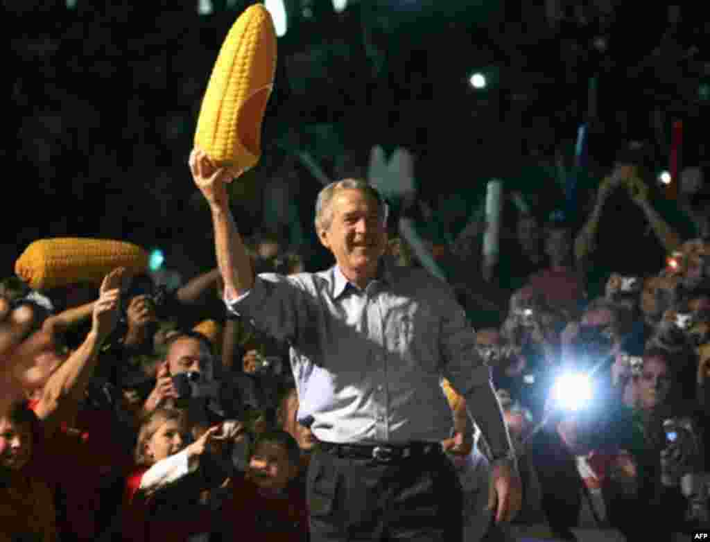 U.S. -- Grand Island : US President George W. Bush holds a plastic corn cob had as he arrives for a campaign rally at the Heatland Events Center, 05Nov2006, in Grand Island, Nebraska.
