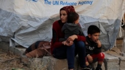 Сирийская женщина и ее дети ожидают получить палатку и другие предметы помощи в лагере для беженцев на севере Ирака, 17 октября 2019 года. Иллюстрационное фото