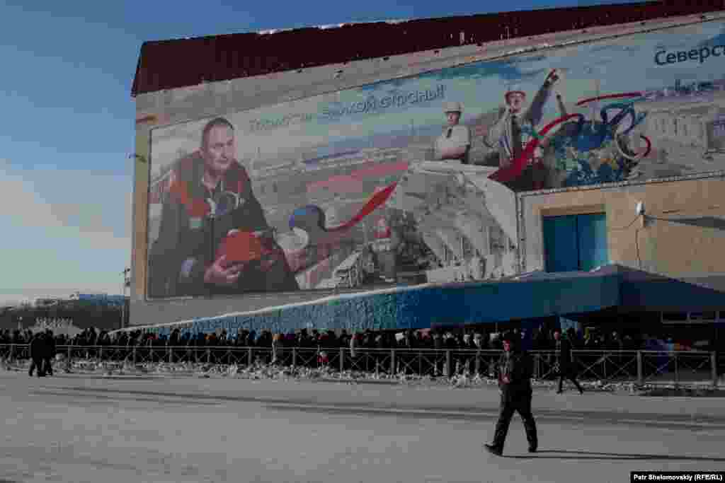 People wait to pay their last respects outside the concert hall where the services took place.