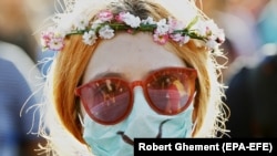 Протест у Бухаресті. Жінка у масці, щоб захистити себе від сльозогінного газу