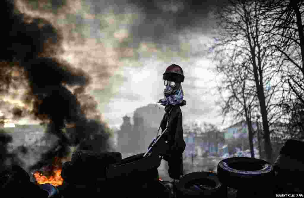 Një gogol (figurë e frikshme), duke qëndruar pranë barrikadës në Kiev të Ukrainës, më 21 shkurt. Pas protestave të dhunshme me kundër forcave qeveritare në qytet, presidenti Viktor Yanukovich iki nga Kievi dhe parlamenti votoi për largimin e tij. (Bulent Kilic, AFP)