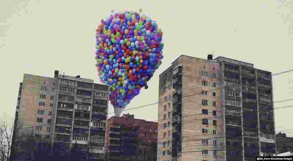 The balloons from the film Up, rising behind Soviet-era apartment blocks. Zubkov says that characters from an "ideal, clean world contrast with dirty provincial streets."