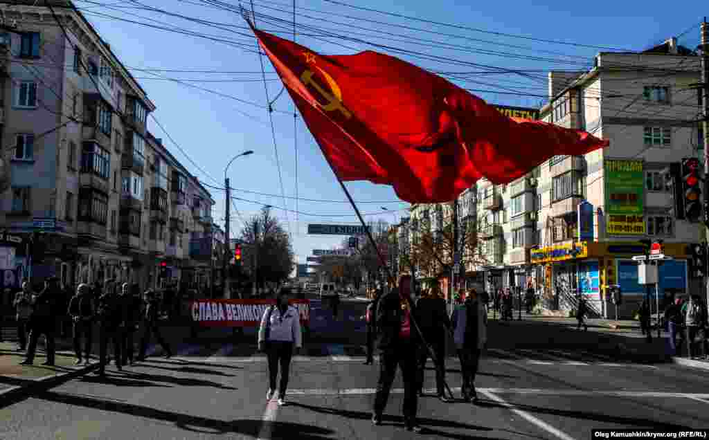 Учасник ходи несе величезний прапор Радянського Союзу. 