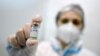 Az orvosi személyzet tagja egy kínai gyártmányú Sinopharm vakcina adagját mutatja be egy belgrádi oltási központban 2021. január 19-én.