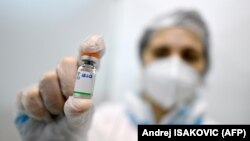 A medical professional shows a dose of the Chinese-made SinoPharm vaccine. 