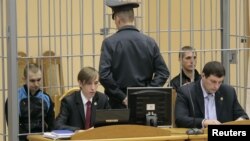 The two convicted metro bombers, Dzmitry Kanavalau (left) and Uladzislau Kavalyou, are pictured here in a cage before court hearings in Minsk in 2011. 
