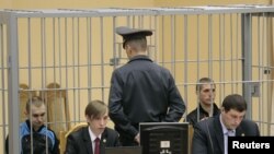 Convicted killers Dzmitry Kanavalau (far left) and Uladzislau Kavalyou (second from right) sit in the dock during court hearings in Minsk in September.