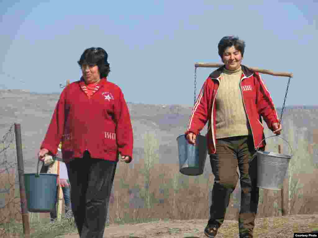 Armenian women carry water to the village of Bagaran.