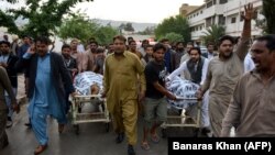 Pakistani Christians push stretchers carrying the bodies of relatives who were killed in a drive-by shooting outside a church in Quetta on April 15.