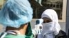 Сирія. Медик перевіряє температуру тіла пасажирки, як запобіжний захід проти коронавірусу, після її приїзду автобусом до курдського району Сирії з Іракського Курдистану, 26 лютого 2020 року