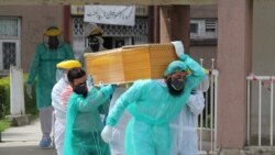 پاکستان کې روغتیايي کارکوونکي په کرونا ویروس د یوه اخته ناروغ د مړي د لېږدولو پر مهال.