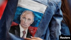 A Russian soccer fan wears a jacket with an image of Russian President Vladimir Putin.