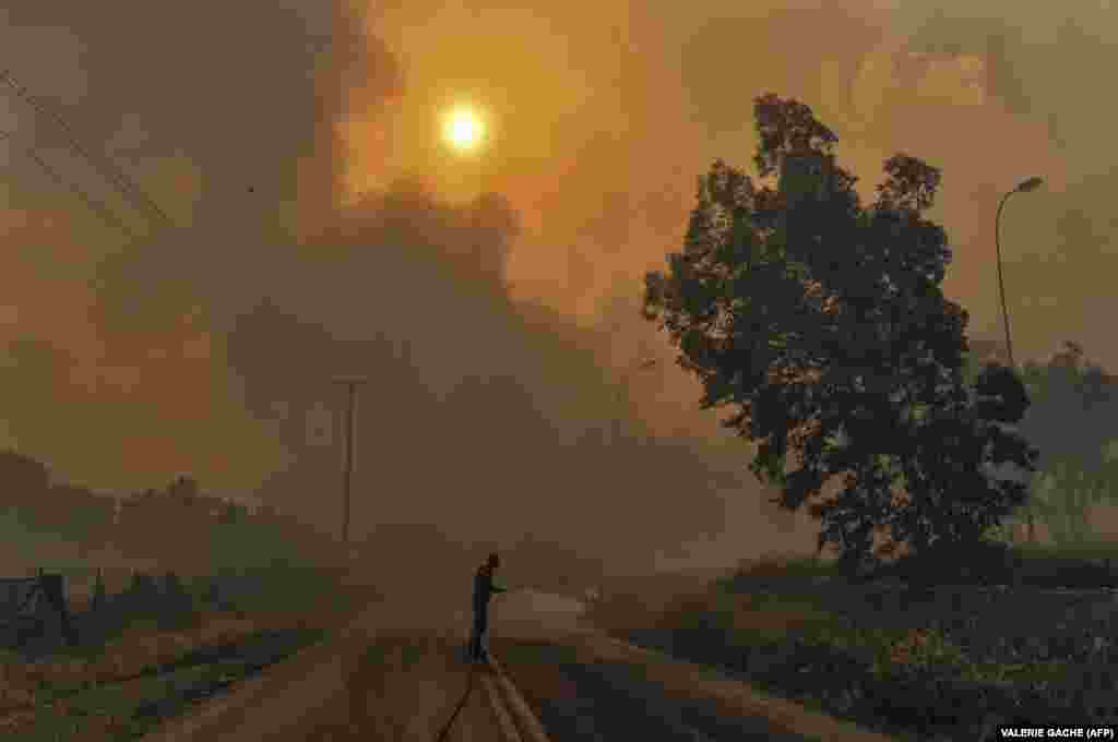 A firefighter tries to extinguish hot spots during a wildfire in Kineta, near Athens. At least 60 people have died in wildfires in the country&#39;s deadliest blazes in more than a decade. Firefighters reported more than 100 people injured in the flames, some of them seriously, and said the death toll is expected to rise. (AFP/Valerie Gache)