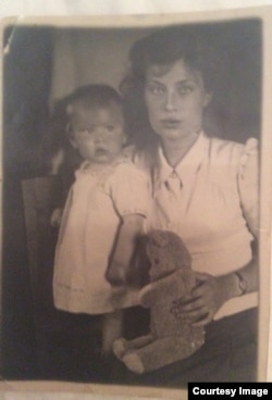 "Это первый официальный снимок меня с мамой. На мне – платье, в котором еще моему отцу делали обрезание, из крепкого белого сукна с голубой вышивкой. Когда я выросла, оно стало платьем моей куклы и позже было потеряно на тюремном этапе. Плюшевый мишка принадлежал фотографу. Моя мать умерла прошлой ночью в своей постели. Ей было 92".