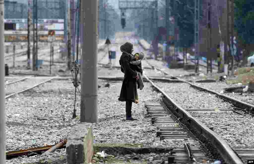 A migrant woman carries her child as they wait to cross the Greek-Macedonian border near Gevgelija on February 8. (AFP/Robert Atanasovski)