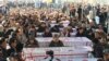 Members of Pakistan's Shi'ite Hazara community gather on January 4 by the coffins of 11 victims killed by unknown gunmen on the outskirts of Quetta, Balochistan Province.