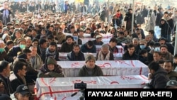 Members of Pakistan's Shi'ite Hazara community gather on January 4 by the coffins of 11 victims killed by unknown gunmen on the outskirts of Quetta, Balochistan Province.