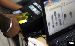 A foreign worker provides his thump print impression as he registers under a new biometric program in Malaysia.