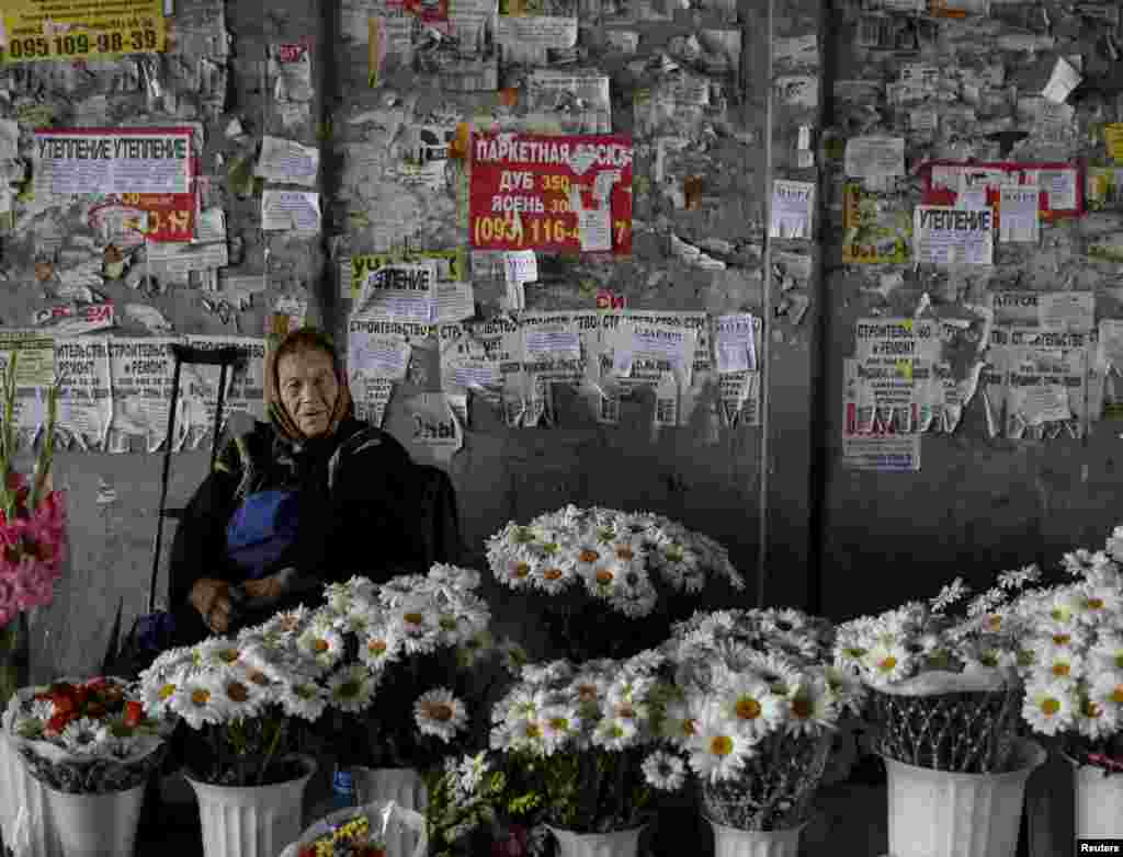 زن گل&zwnj;فروش در زیر پلی در کی&zwnj;یف، اوکراین. ۱۶ ژوئیه ۲۰۱۵.