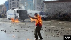 Стамбул, 11 июня 2013 года. Во время разгона полицией демонстрантов на одном из них загорелась одежда