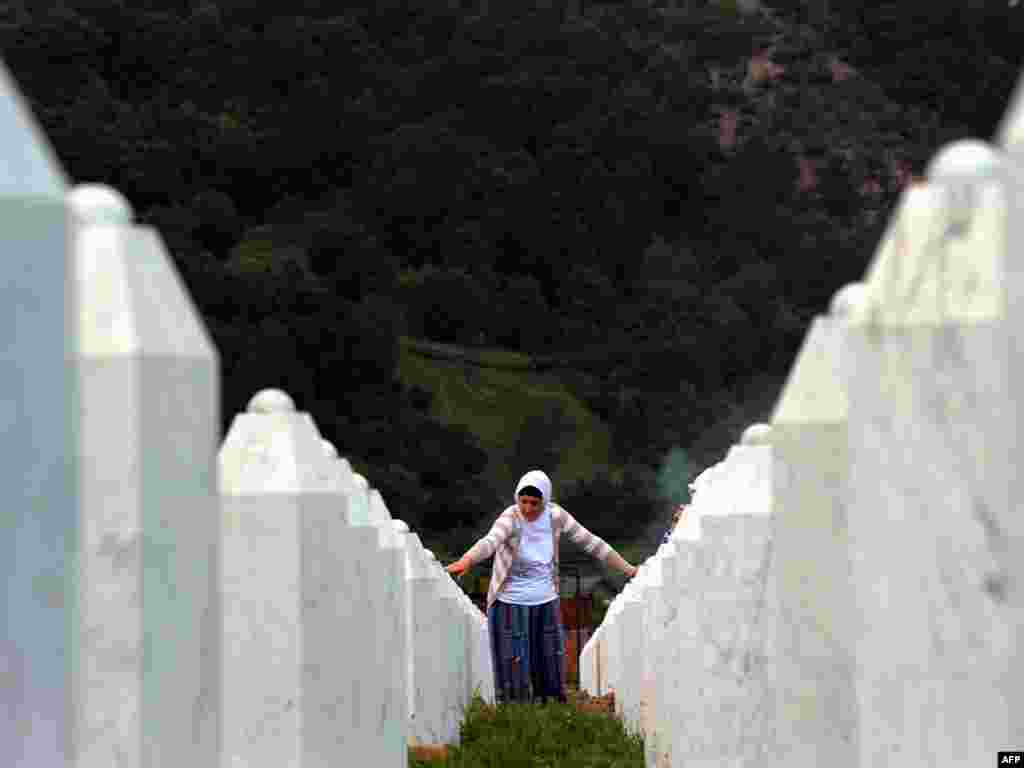 A Bosnian woman touches gravestones at the Potocari memorial cemetery near Srebrenica, Bosnia. On July 11, Bosnians marked the 15th anniversary of the wartime Srebrenica massacre of nearly 8,000 Muslim males by Serb troops. Photo by Dimitar Dilkoff for AFP