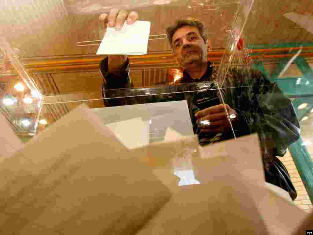 Caption: epa01243335 A man casts his ballot at a polling station in Belgrade, 03 February 2008. Serbs are voting in the presidential elections run-off