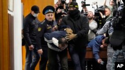 Муродали Раџабализода, осомничен за пукањето во Градското собрание на Крокус, е придружуван од руската полиција во судот во Москва на 24 март