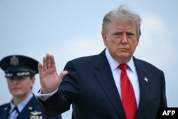US President Donald Trump waves as he boards Air Force One at Joint Base Andrews, Maryland, en route to Michigan on July 27.