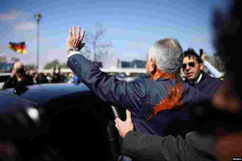 Реза Пехлеви, сын последнего шаха Ирана, находящийся в изгнании, и деятель иранской оппозиции, испачканный красной жидкостью, уходит после пресс-конференции в Берлине, Германия, 23 апреля 2026 года. REUTERS/Liesa Johannssen