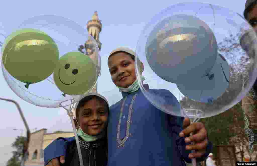 Boys holding balloons after Eid prayers at a mosque in Karachi, Pakistan.