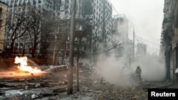 Firefighters work to extinguish a fire near the site of a building destroyed during a Russian missile strike in central Kyiv on December 20.