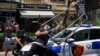 Disa protestues duke sulmuar një veturë policore në Tiranë më 2 korrik 2026. 
