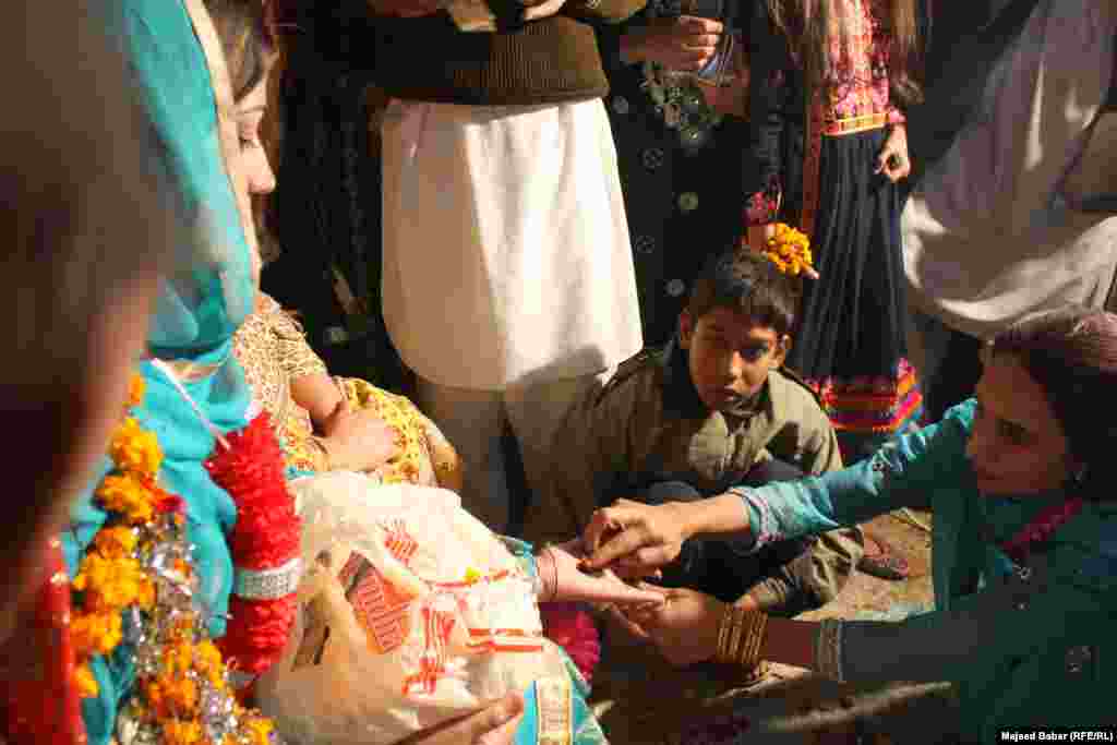 The bride getting henna tattoos on her palm.